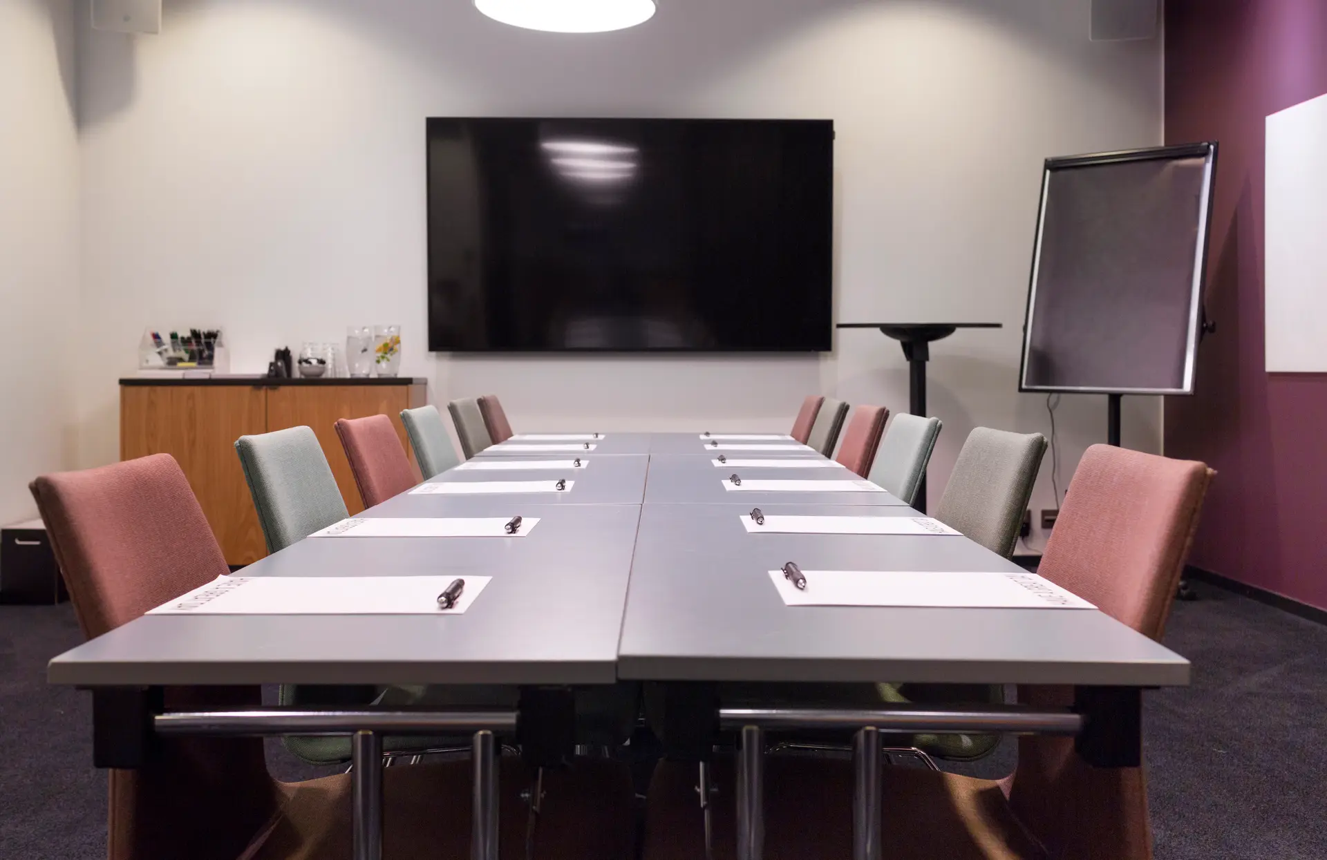 Empty corporate meeting room with a large screen, ready for the next morning