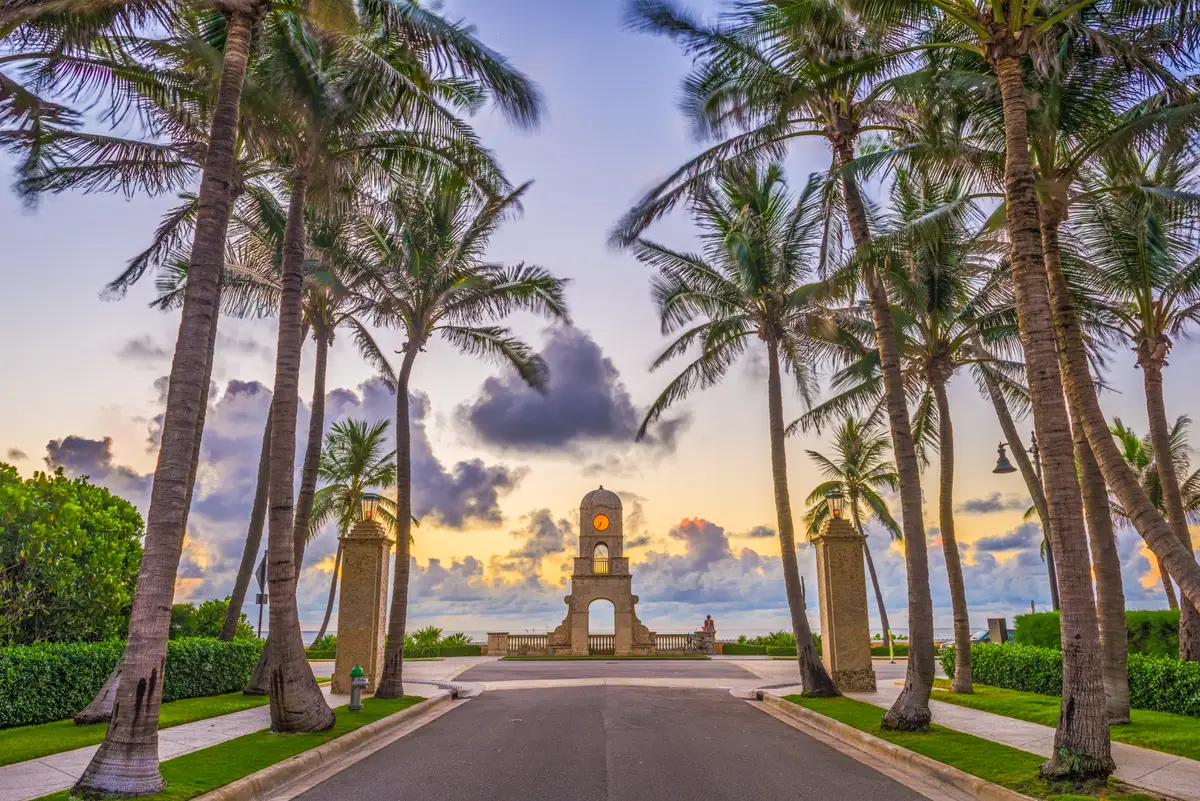 The Worth Avenue clock tower framed by palm trees at sunrise, Palm Beach, Florida