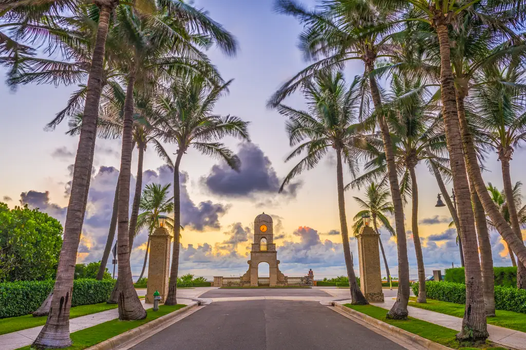 The Worth Avenue clock tower framed by palm trees at sunrise, Palm Beach, Florida